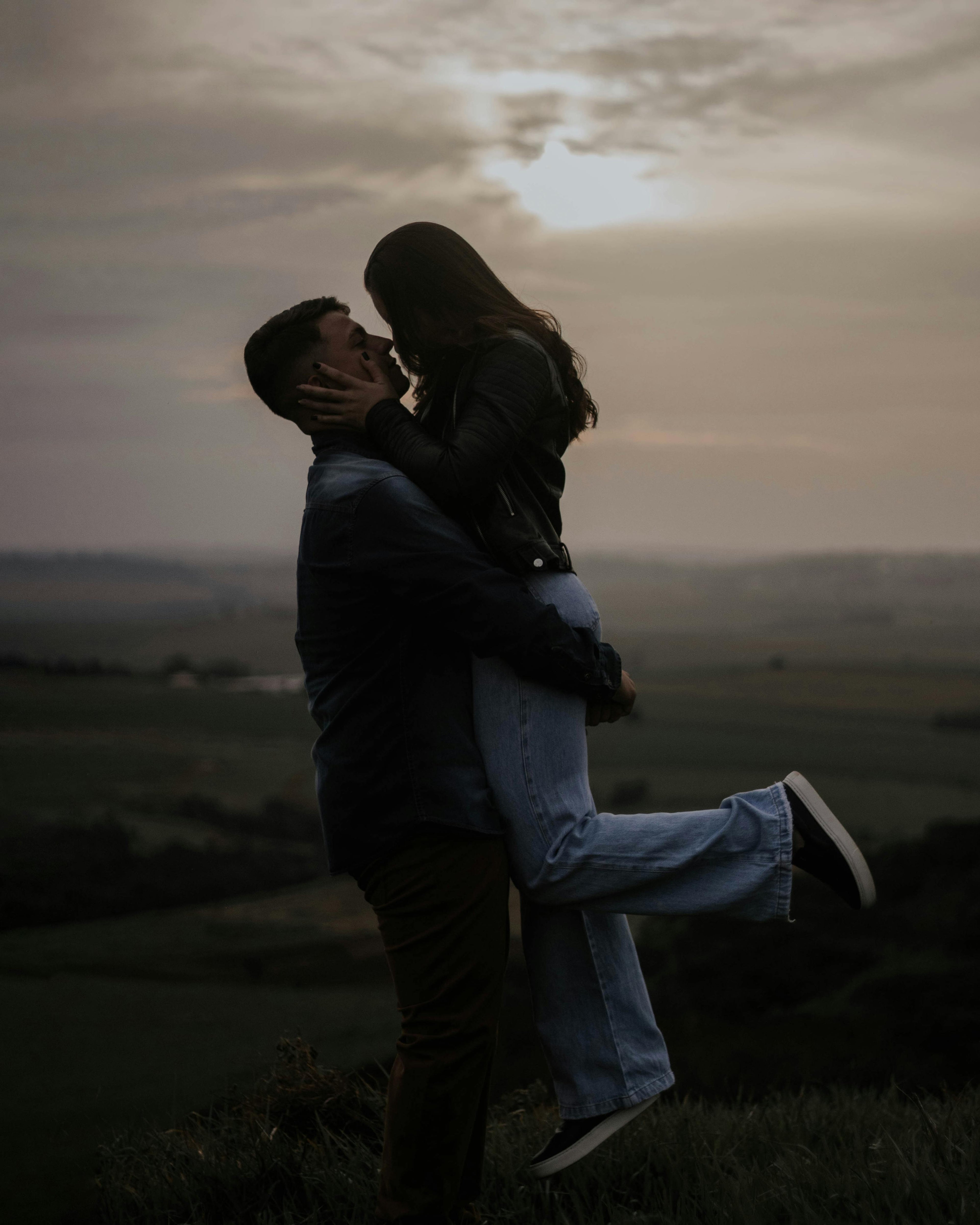 Couple embracing at sunset with a scenic background